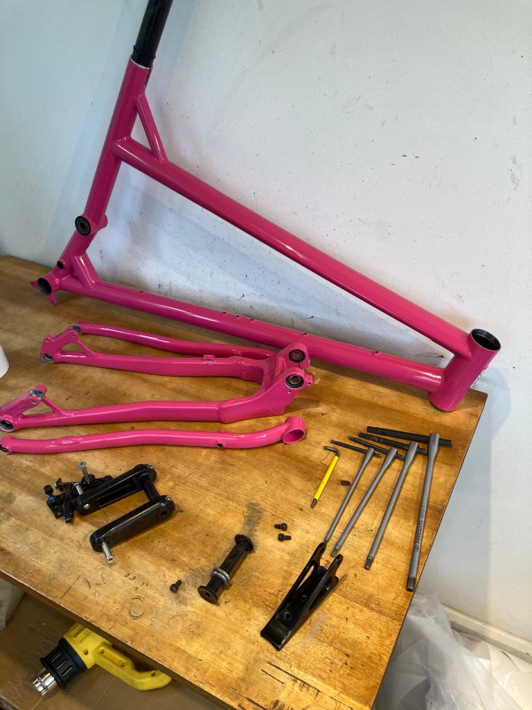 Custom magenta vinyl wrap on a Cotic full suspension frame